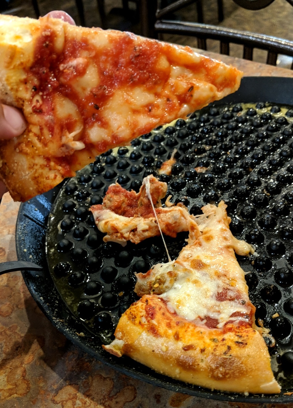 Cheese falling off a slice of pizza